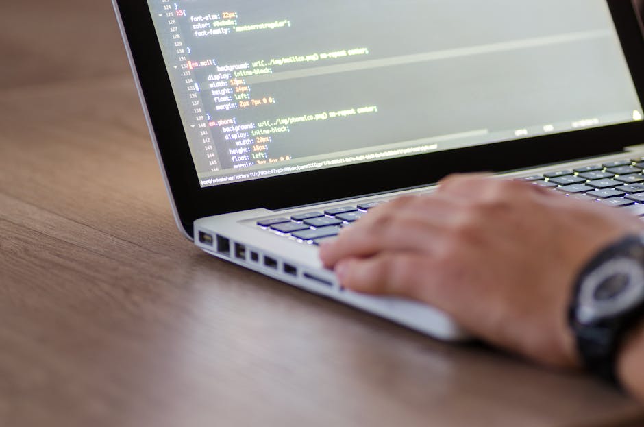 A close-up view of a laptop computer screen displaying a dark-themed code editor with a JavaScript file open, showing lines of code including HTML tags, image sourcing, and other elements related to w